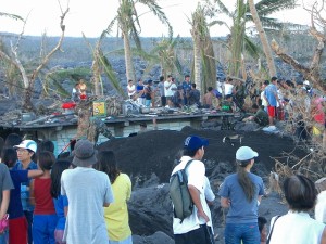 台風レミン、土石流で埋もれた民家の救出作業を見守る人々